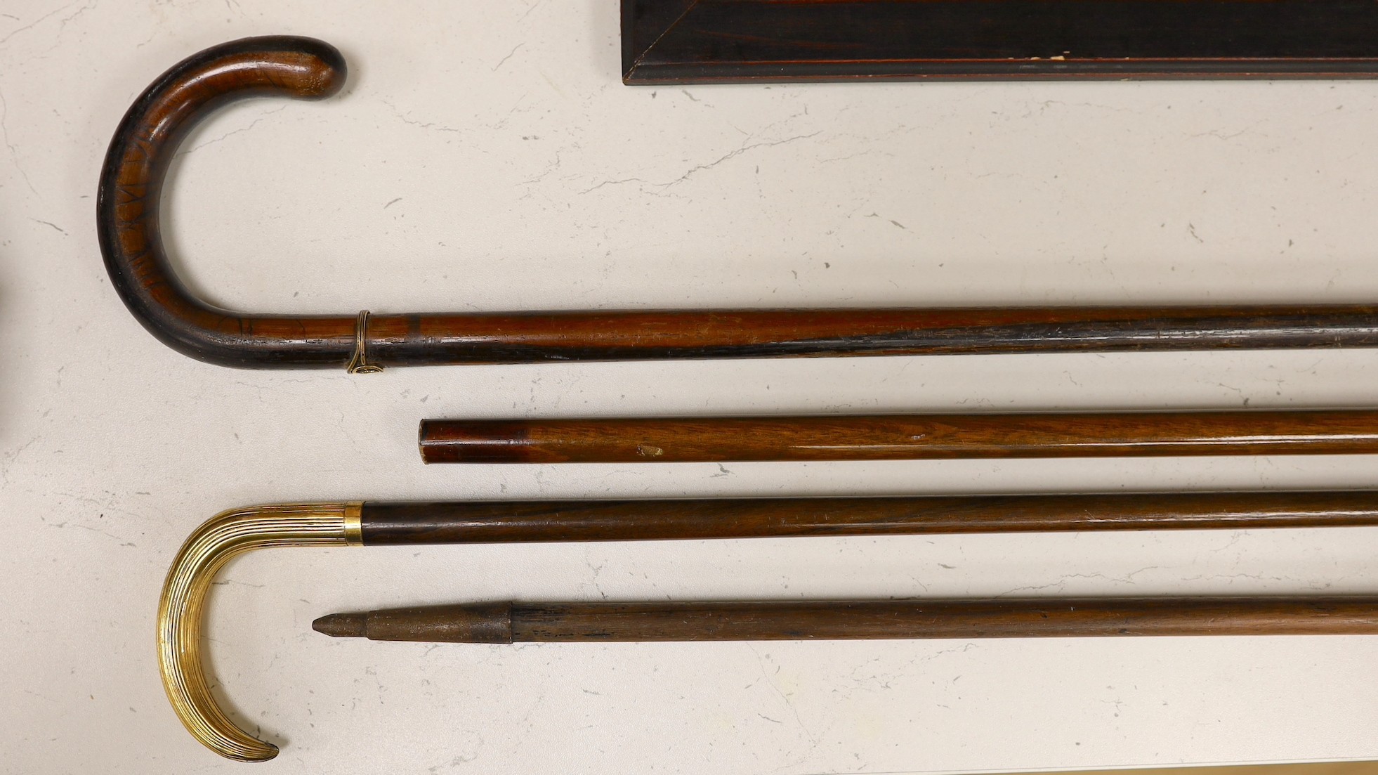 Four various walking sticks, one silver mounted and another gilt metal mounted and impressed ‘Antoine’